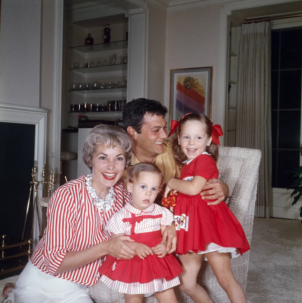 Actors Tony Curtis and Janet Leigh with their two young daughters, Kelly Lee and Jamie Lee, in their home.