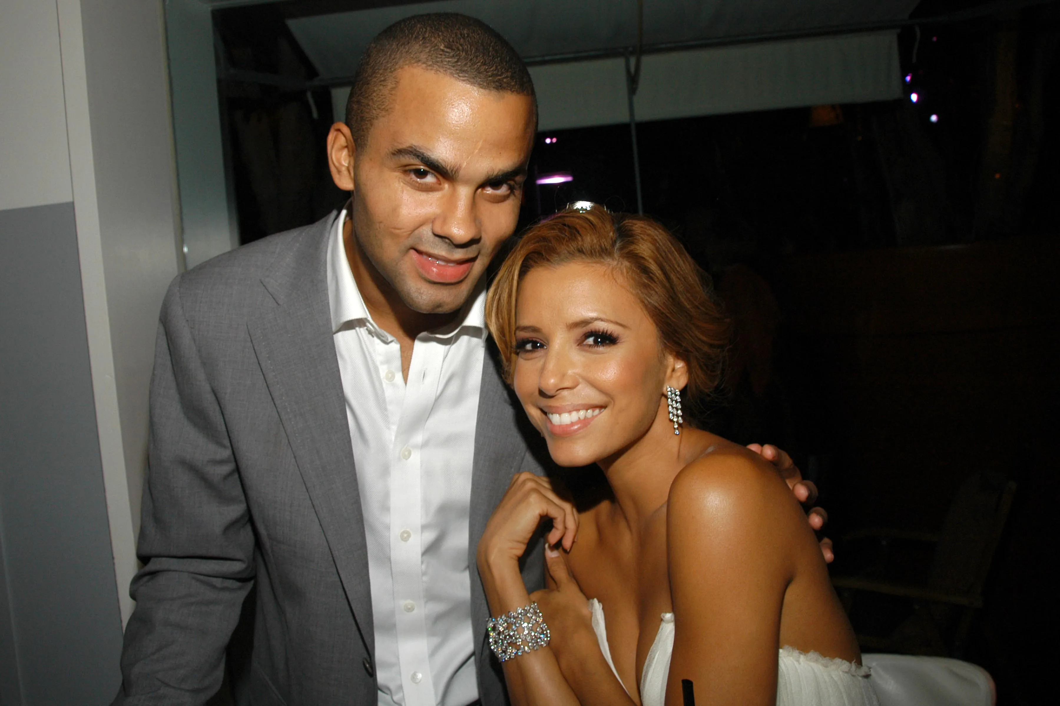 Tony Parker and Eva Longoria smiling at a party.