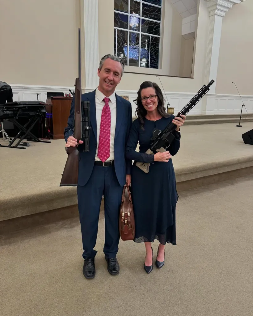 Tony Spell and his wife, Shaye Spell, smiling and holding guns in what appears to be a church.