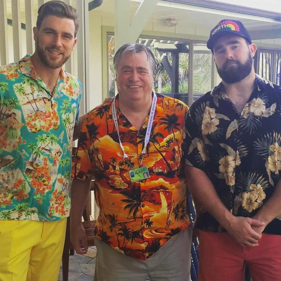 Travis Kelce, his father Ed, and Jason Kelce posing in Hawaiian shirts.