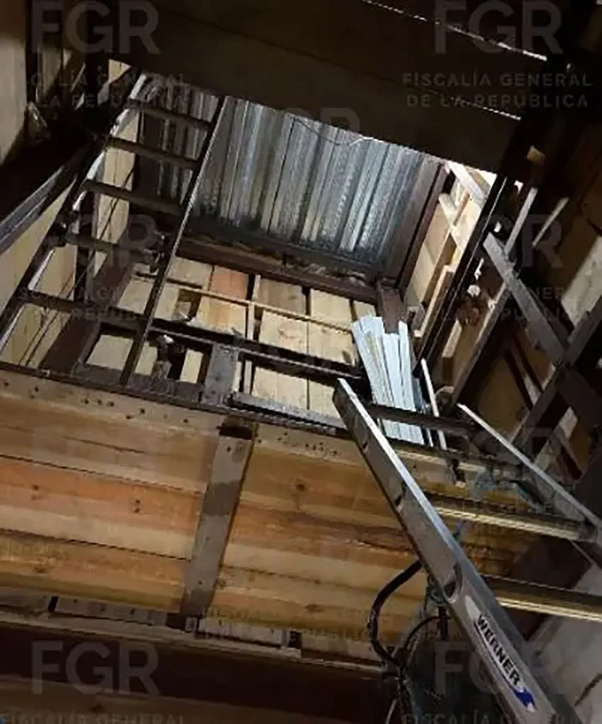 A tunnel near the Tijuana-San Diego border, showing a ladder leading into a deep, wooden and metal-lined shaft.
