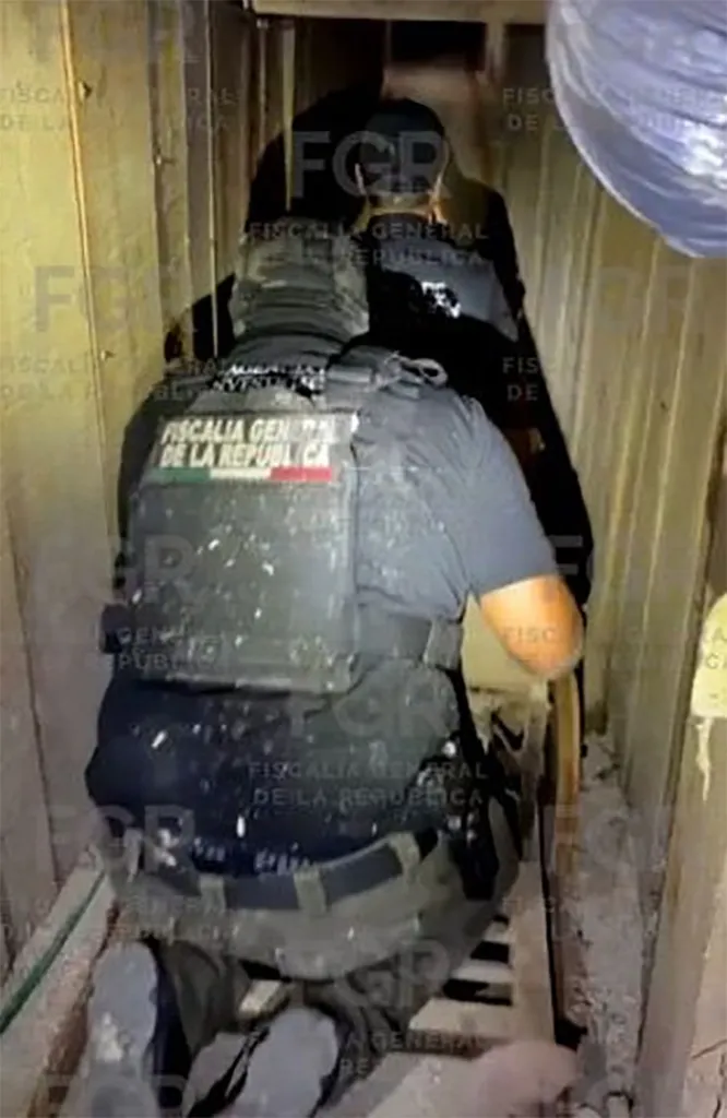 A Mexican Attorney General's Office agent in protective gear inspecting a tunnel near the Tijuana-San Diego border.