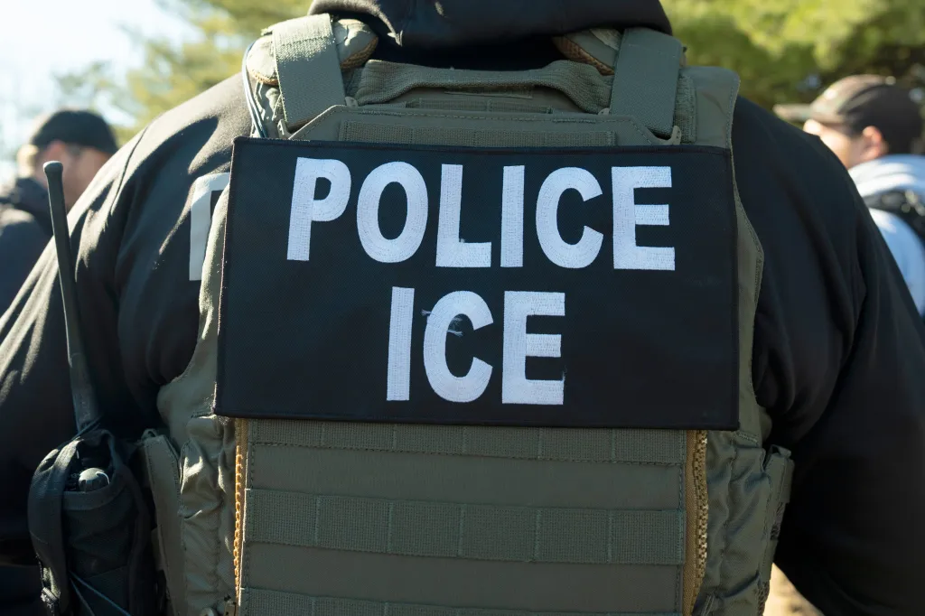 Back of an ICE police officer in uniform.