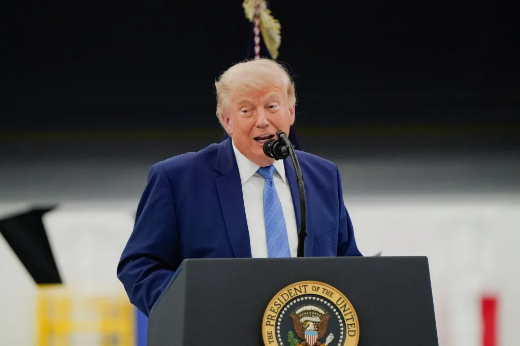 Donald Trump speaking at a podium with the Presidential Seal at Joint Base Andrews.