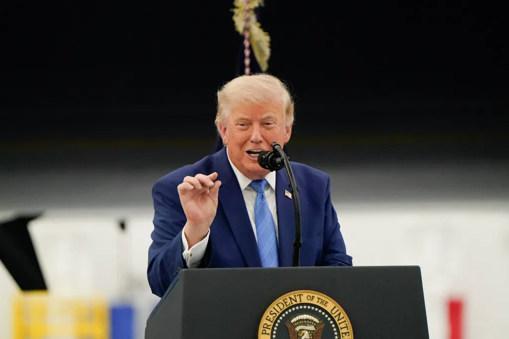President Trump speaking at a podium with a microphone.