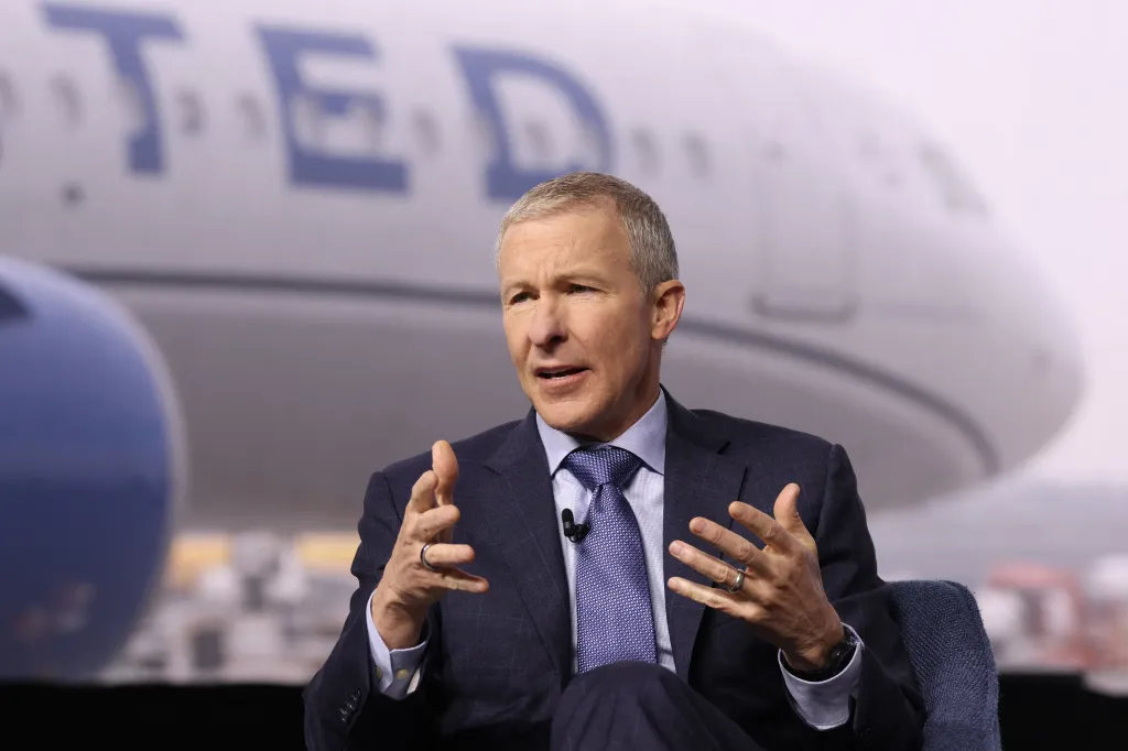 United Airlines CEO Scott Kirby speaking in front of an airplane.