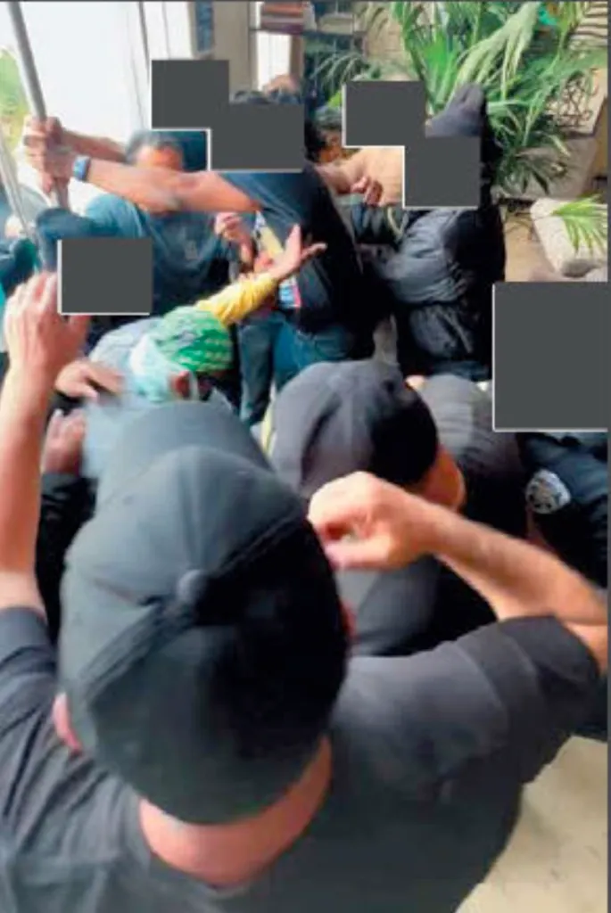 Several men appear to be involved in a struggle or altercation.
