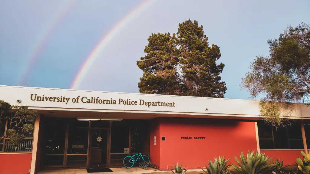 The University of California Police Department building with a rainbow in the sky.