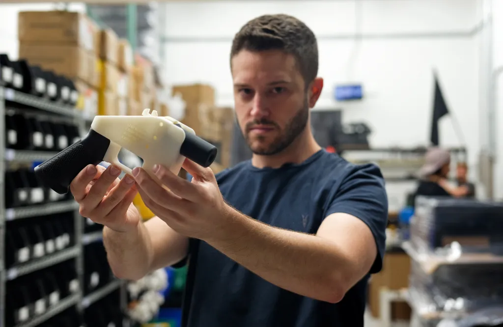 Cody Wilson, owner of Defense Distributed company, holds a 3D printed gun, called the 