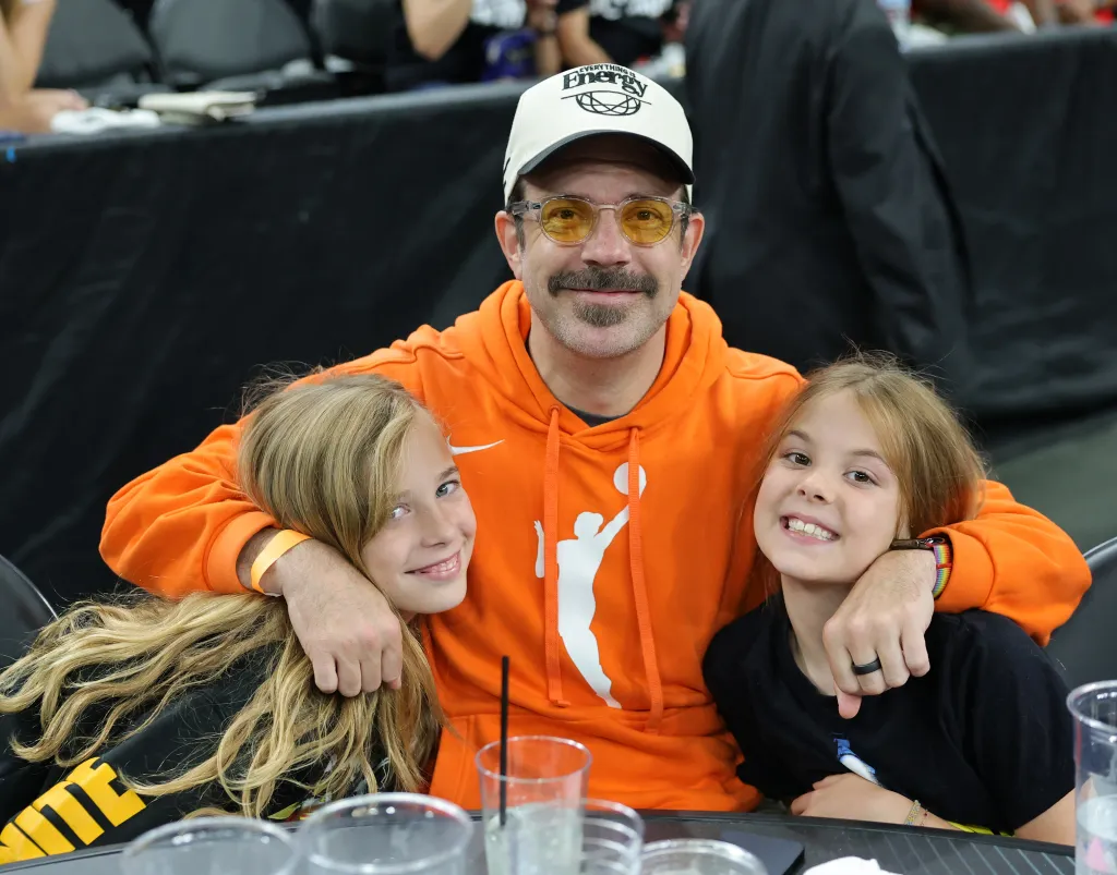 Jason Sudeikis and his children, Otis and Daisy, pose at halftime of a basketball game.