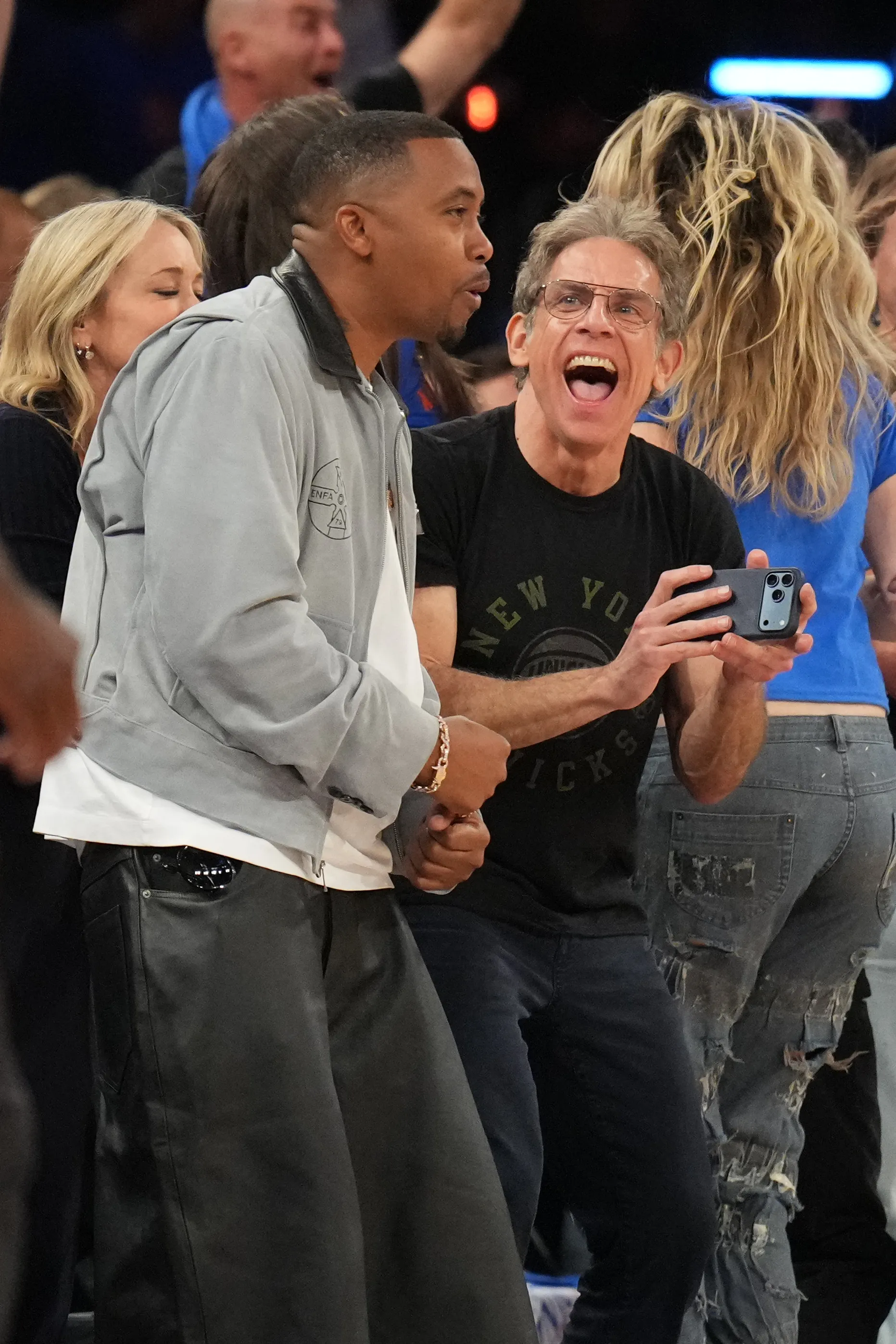 Rapper Nas and actor Ben Stiller watch a basketball game.