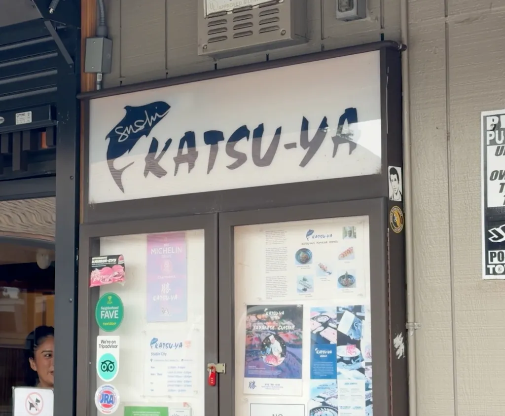 The exterior of Katsu-Ya Sushi restaurant on Ventura Boulevard, featuring the restaurant's sign and promotional materials.