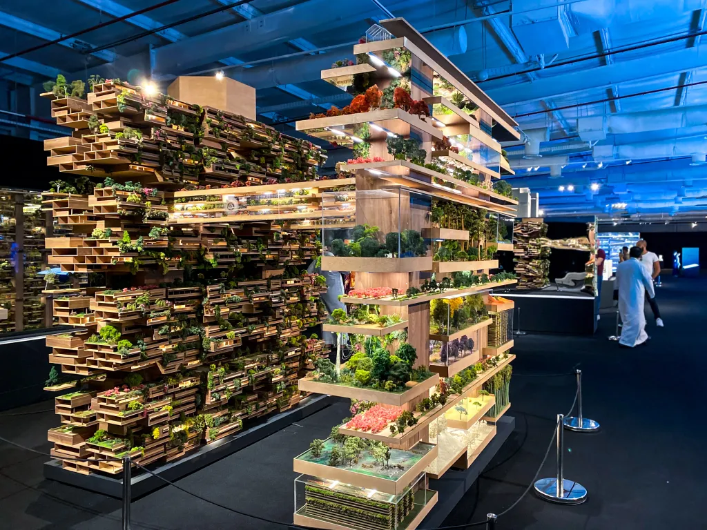 Models of 'The Line' project in Saudi Arabia, featuring vertical layers of greenery and buildings.