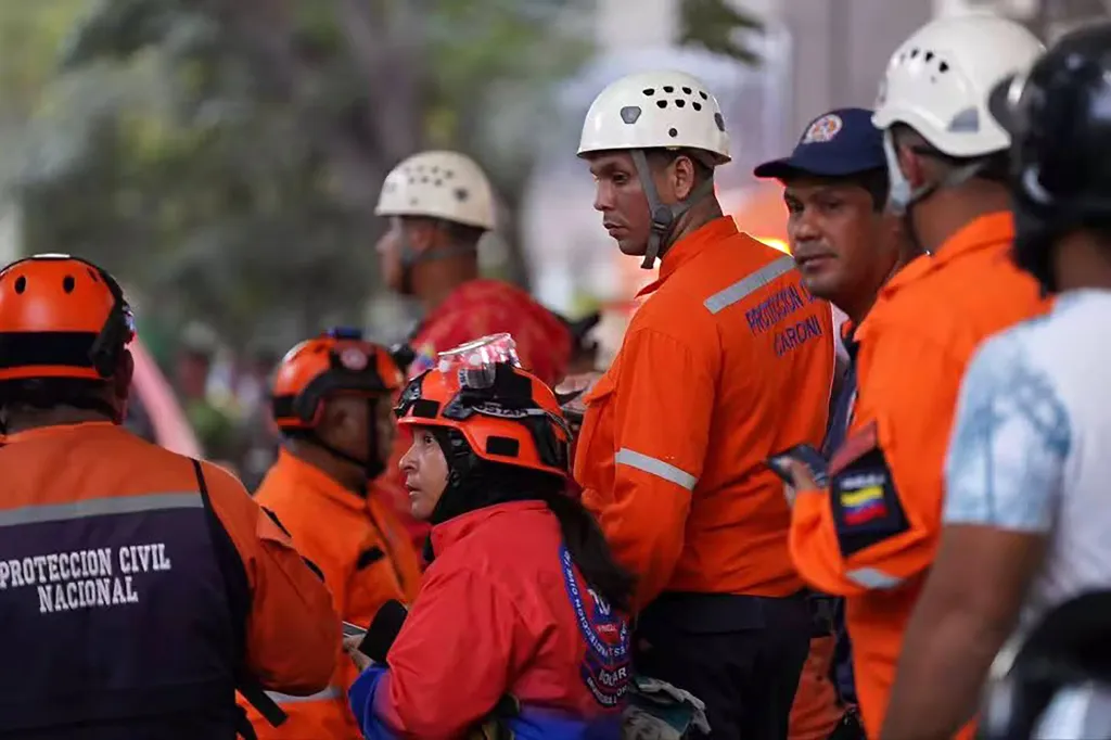 Rescue workers in orange and black uniforms and helmets.