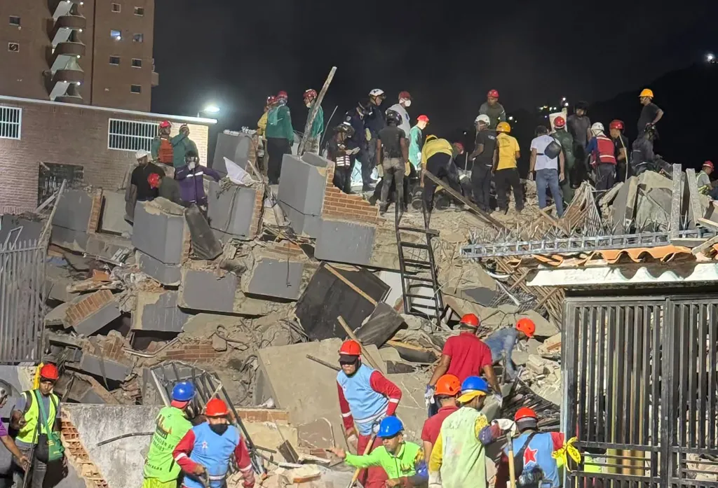 Volunteers and rescue workers on a pile of rubble from collapsed buildings after an earthquake in La Guaira, Venezuela.