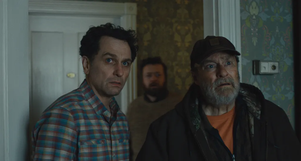 Matthew Rhys and Stephen Root with Kate O'Flynn in the background, all looking surprised.
