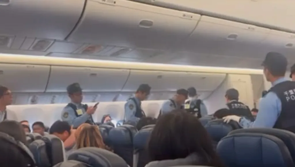 Police officers inside an airplane following a flight diversion.