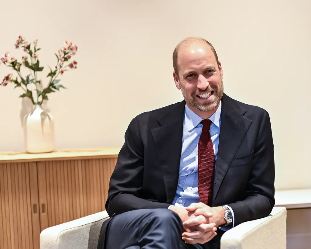 Prince William sitting and smiling.
