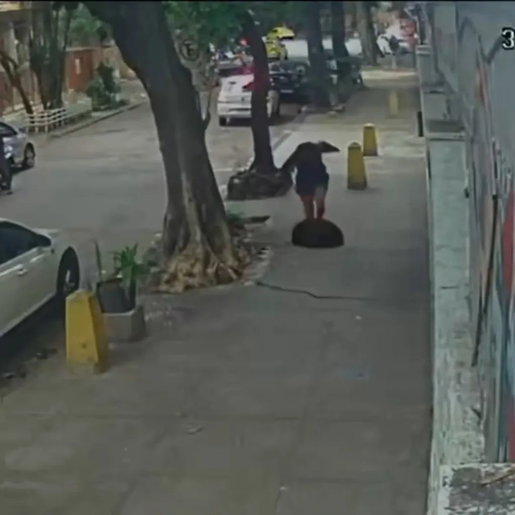 Woman falling into an open manhole on a sidewalk.