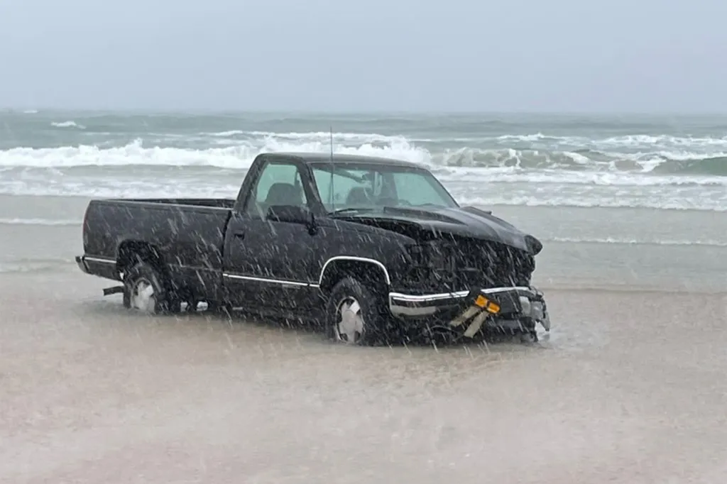 Harrell drove the car on the sand and into the waves, wild footage shows.
