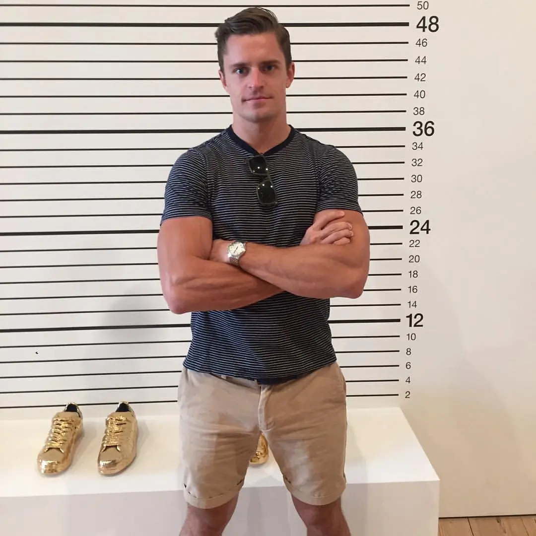 Kevin Sobieski standing in front of a height chart next to two golden shoes.