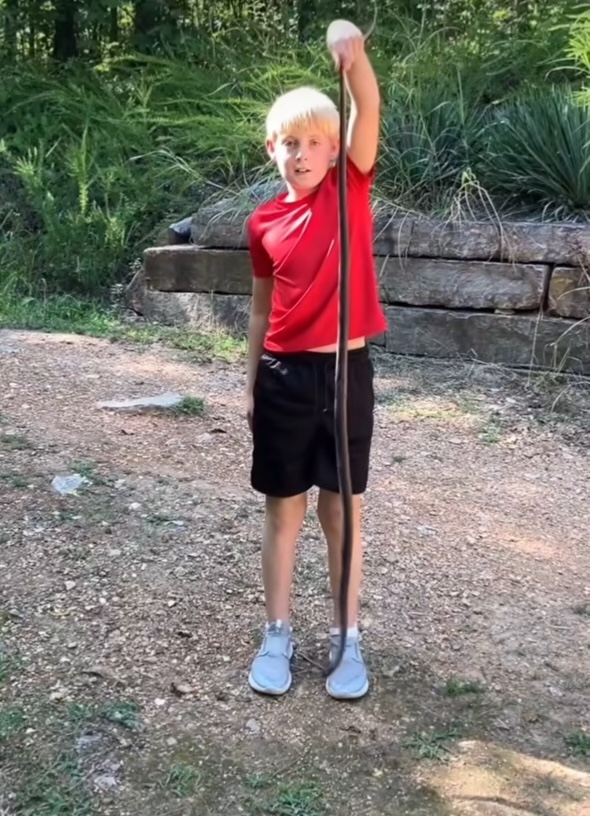Elijah holds up a large snake.
