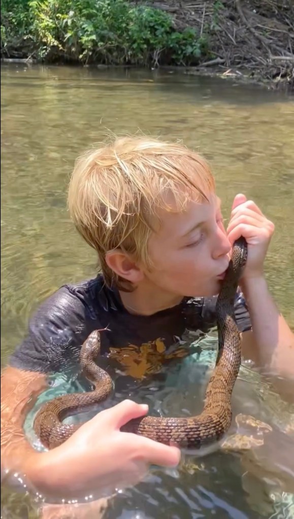 Koto kissing a snake in a river. 