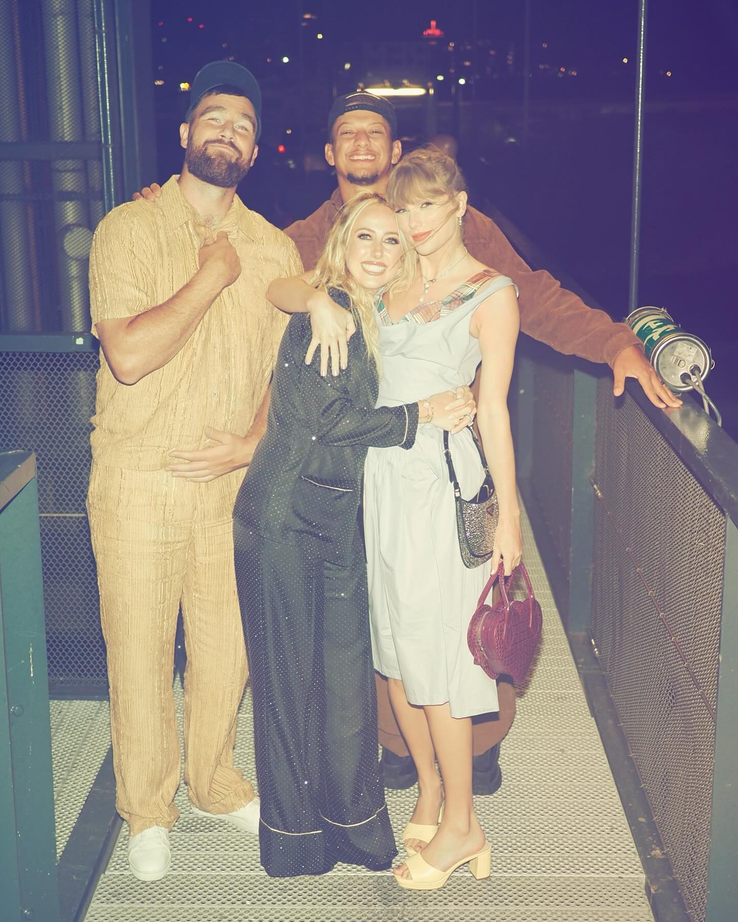 Brittany Mahomes, Taylor Swift, Patrick Mahomes, and Travis Kelce posing together at night.