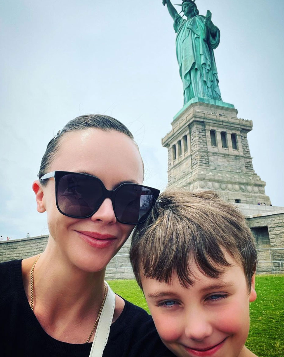 Christina Ricci and her son posing in front of the Statue of Liberty.