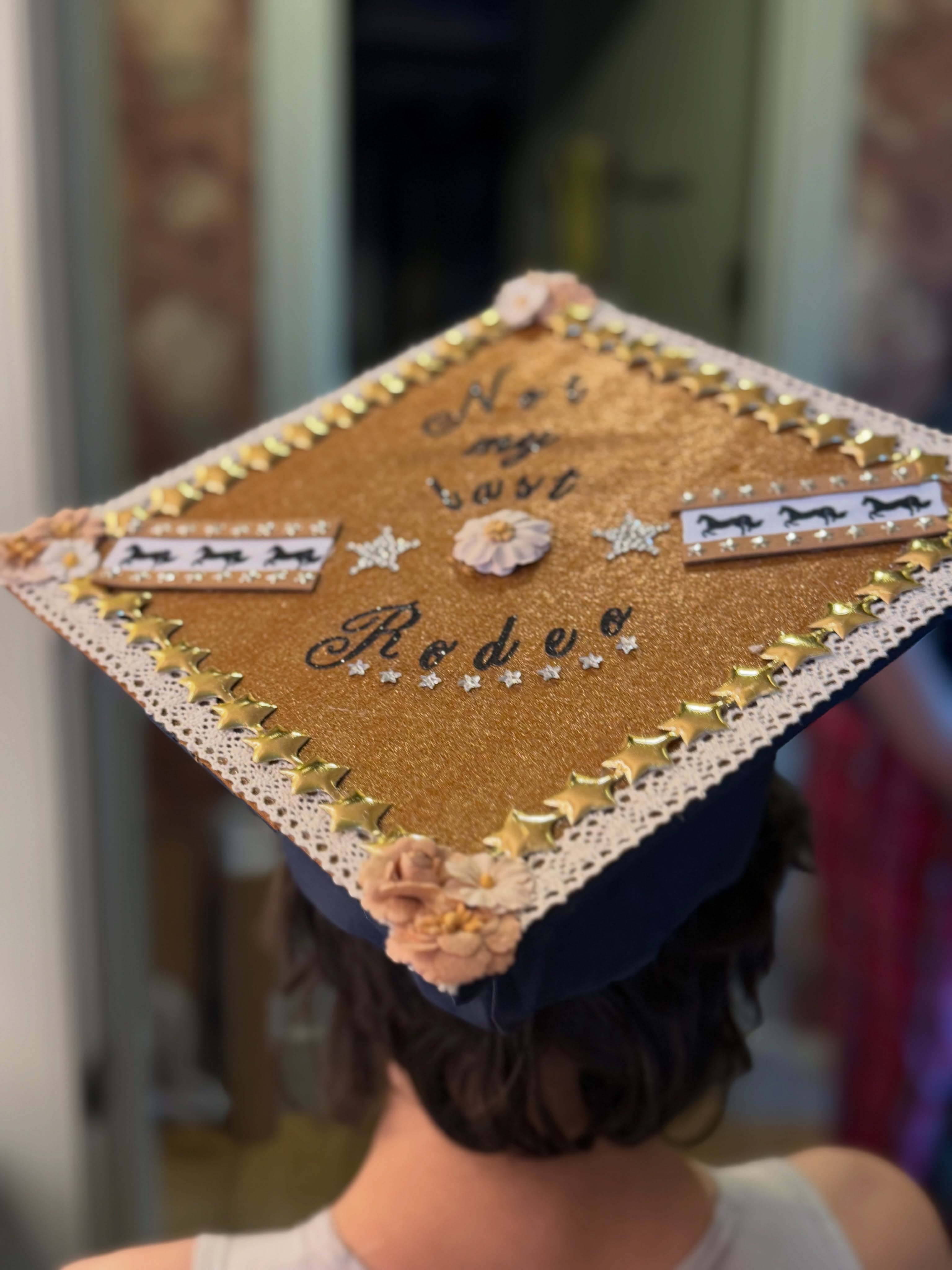 A close-up of a graduation cap decorated with the phrase 