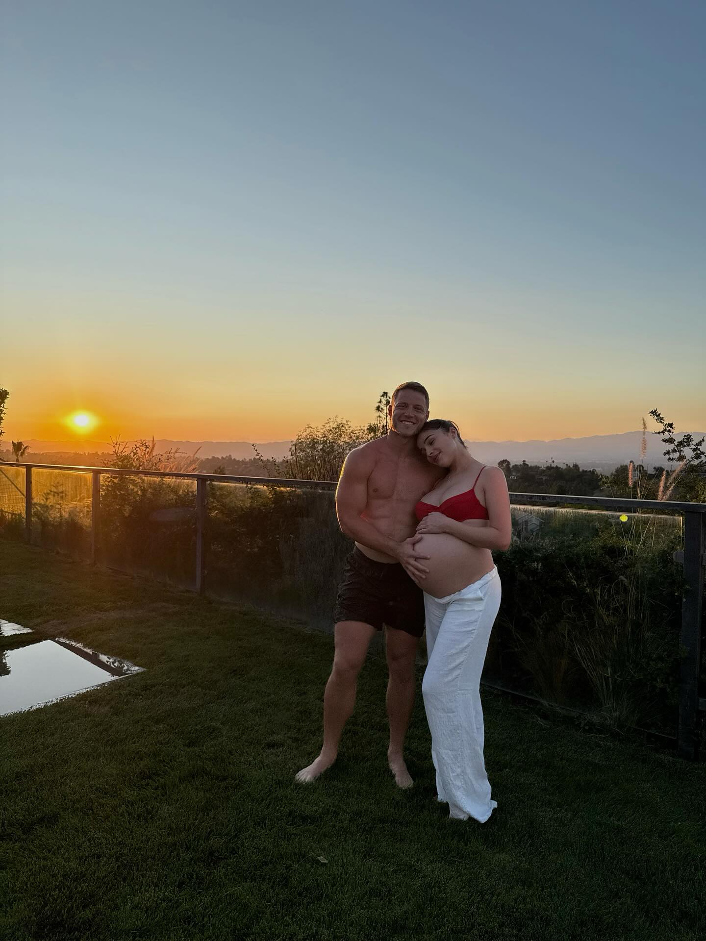 Olivia Culpo and Christian McCaffrey posing together at sunset.