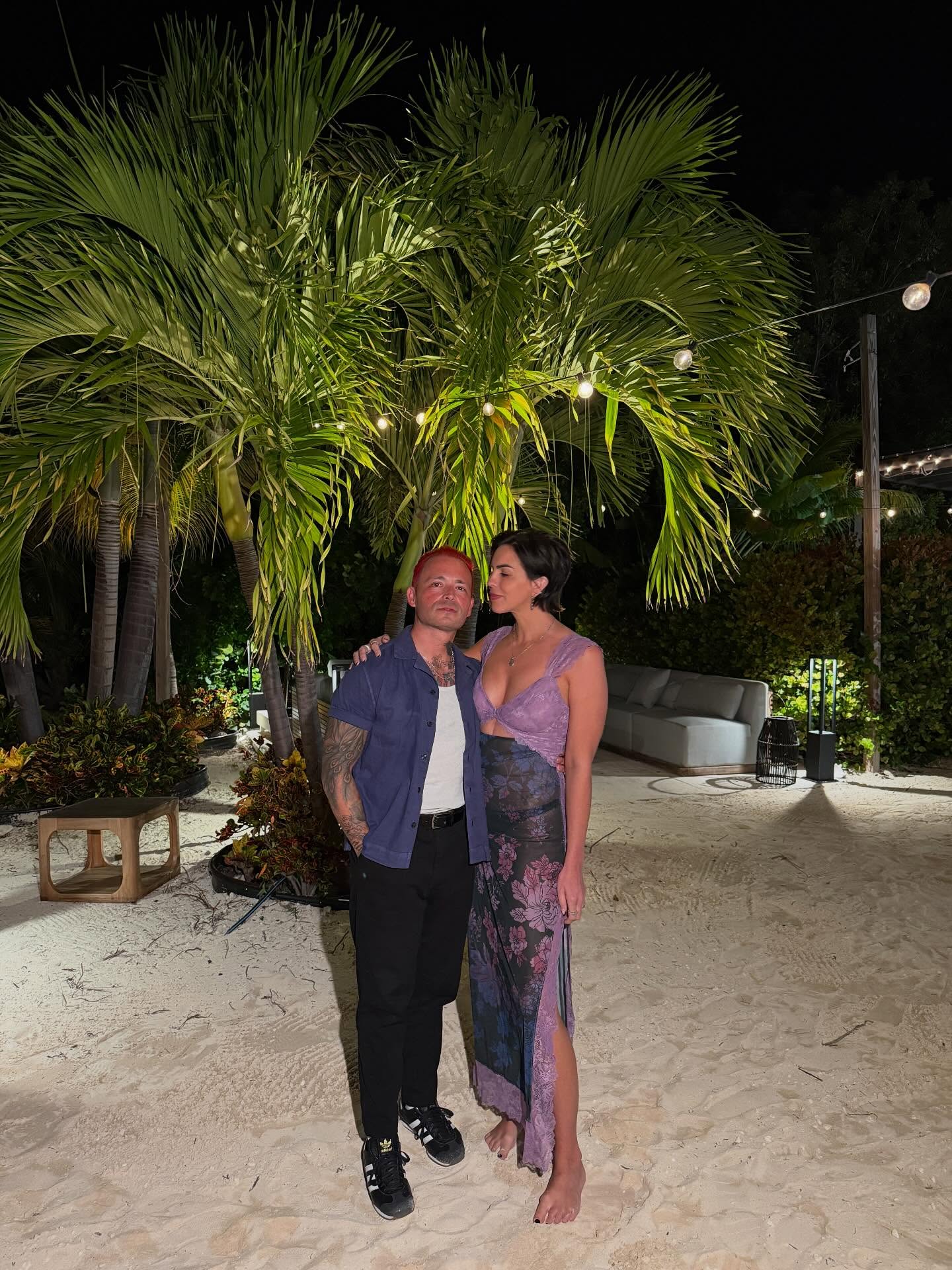Katie Maloney and Nick Martin on a sandy outdoor patio at night.