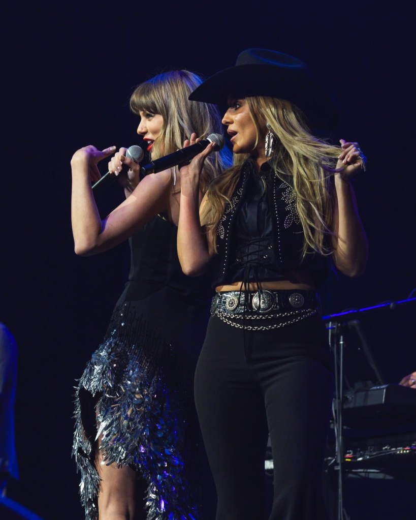 Taylor Swift and Lainey Wilson singing together on stage.