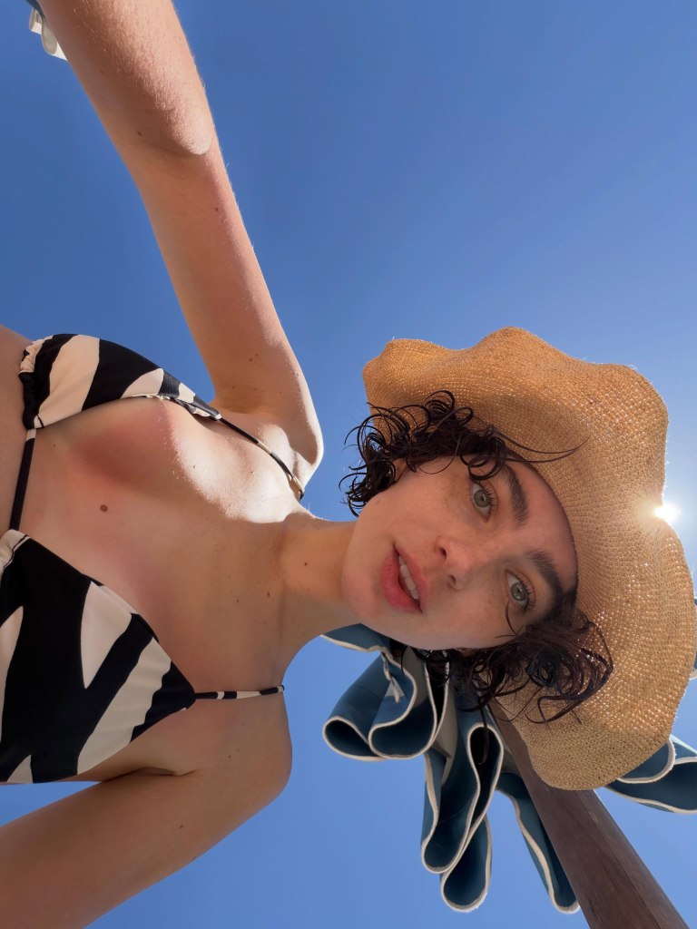 Meadow Walker on vacation, wearing a bikini and straw hat.