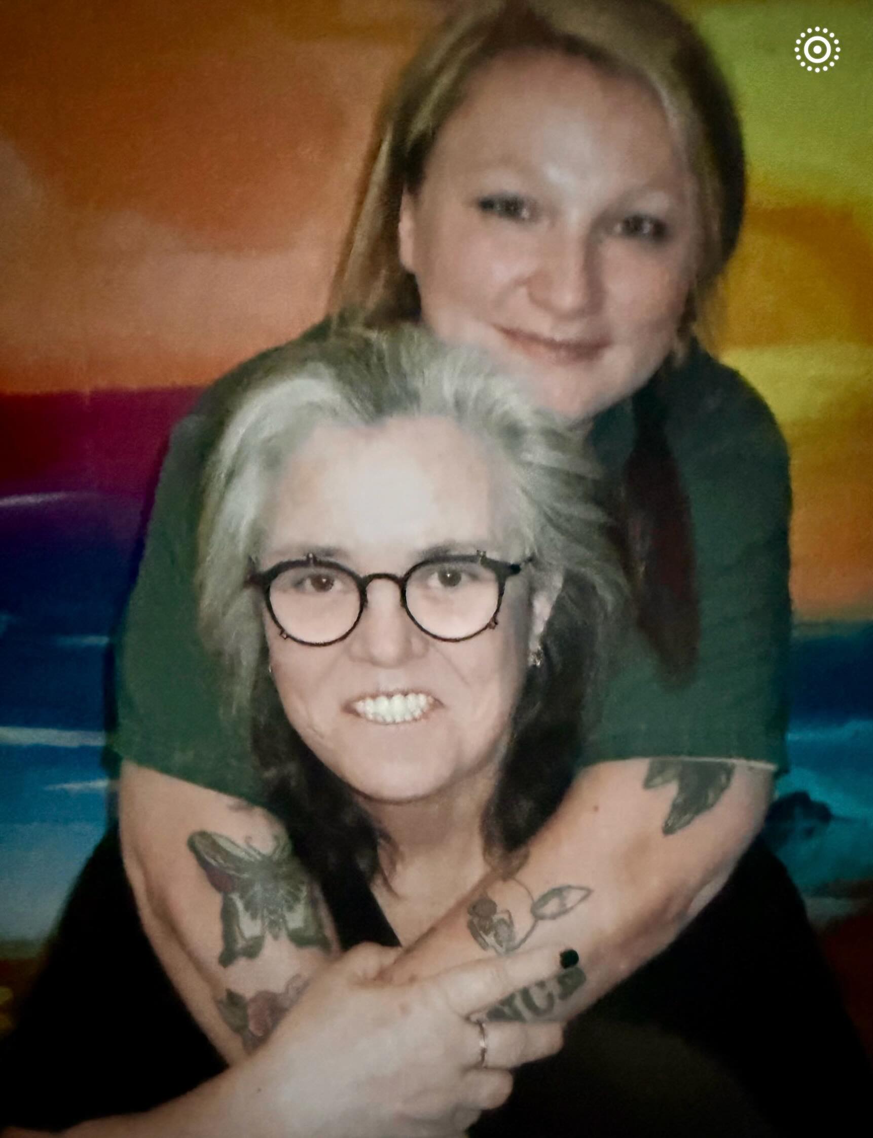 Rosie O'Donnell and her daughter Chelsea embracing with Chelsea's arms around O'Donnell's neck and her left arm tattooed with a butterfly.