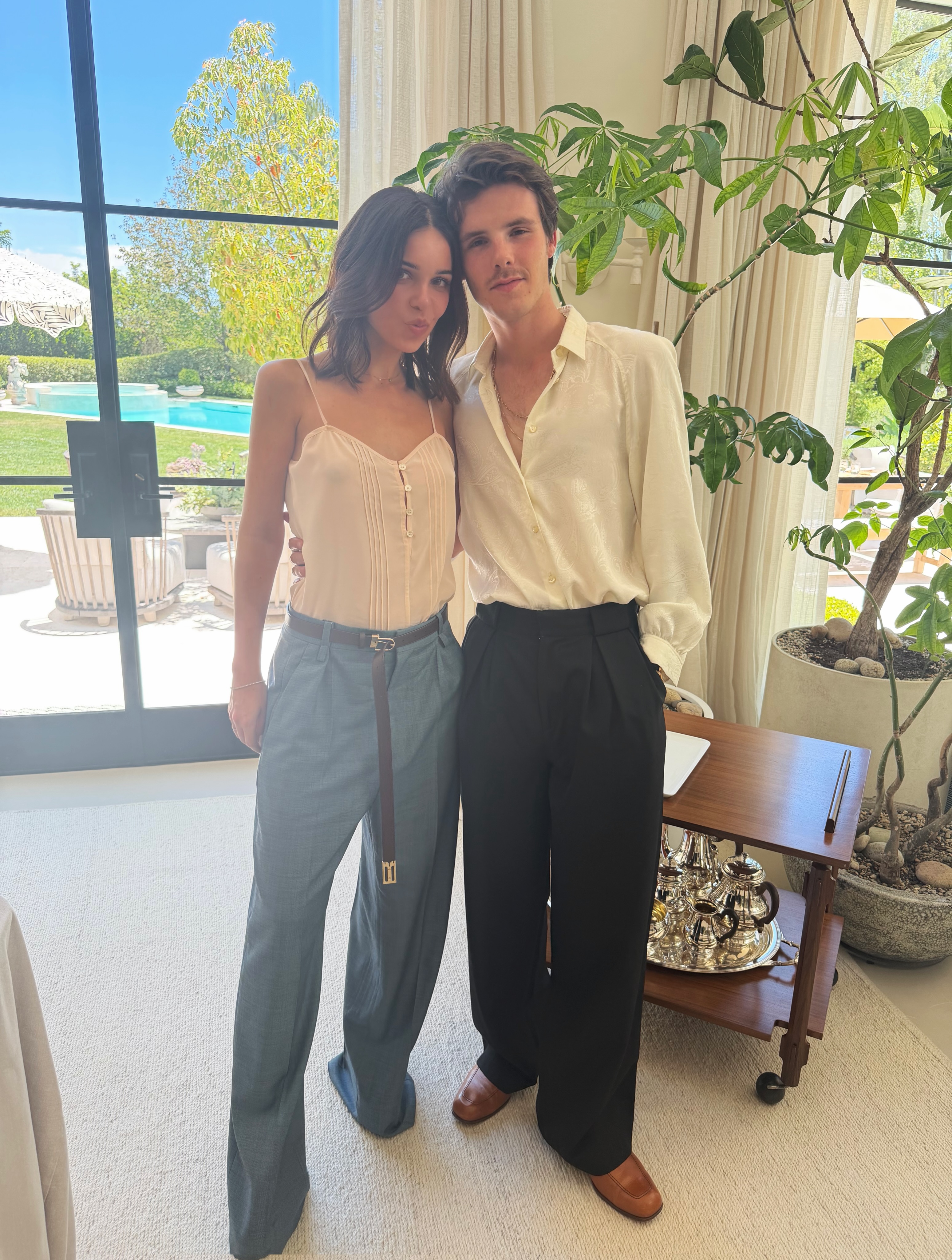 Cruz Beckham and Jackie Apostel standing indoors.