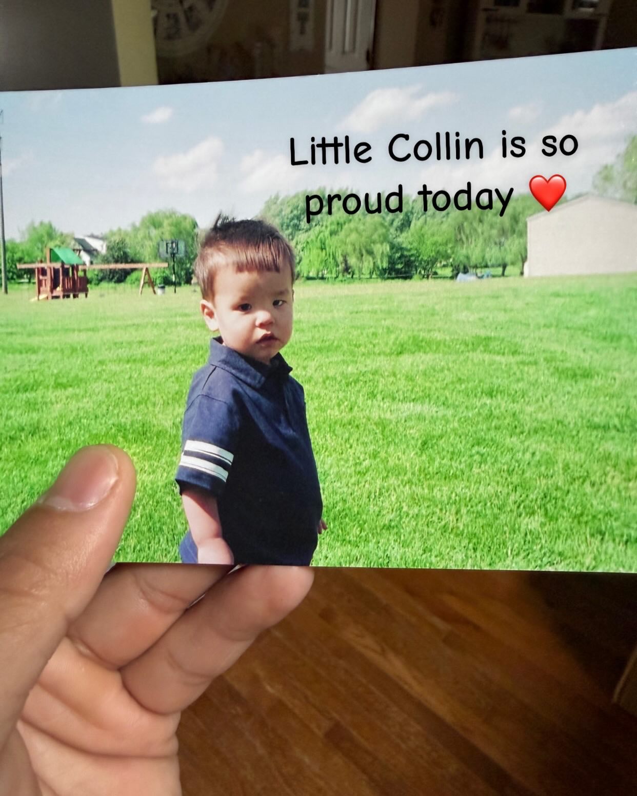 Collin Gosselin holding a photo of a young Collin in a blue polo shirt standing in a grassy field with text 