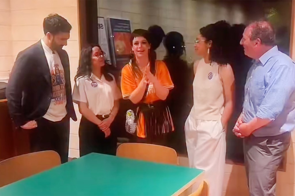 Five people talking around a green table.