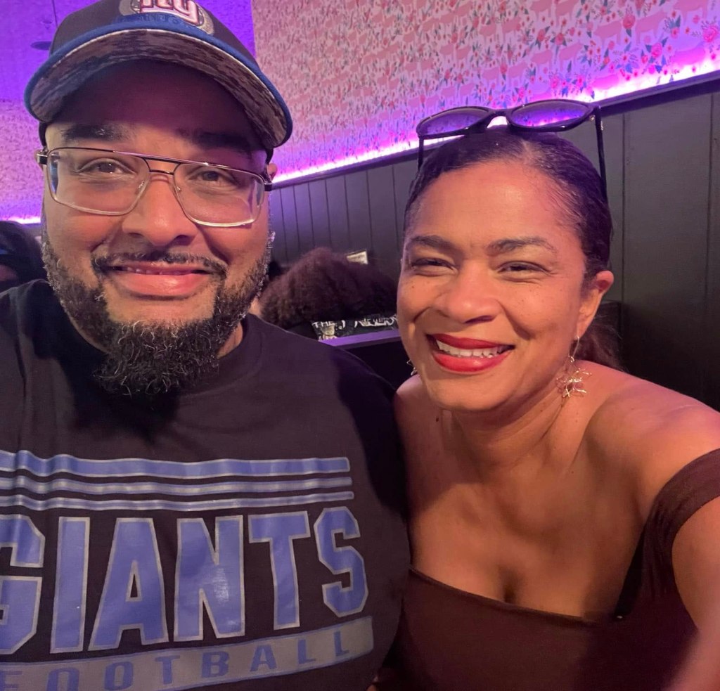 Gregory Toone and Yenny Disla-Toone smiling for a selfie.