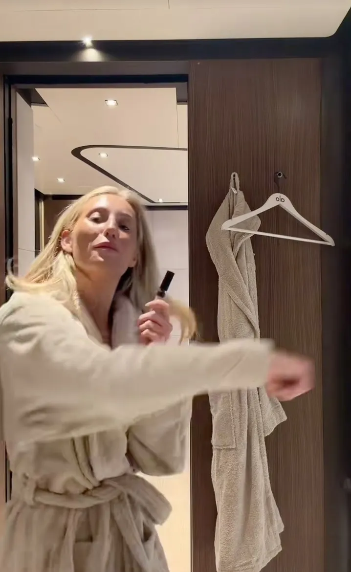 Alix Earle in a bathrobe, with a small bottle in her hand, talking about being punched in Monaco.