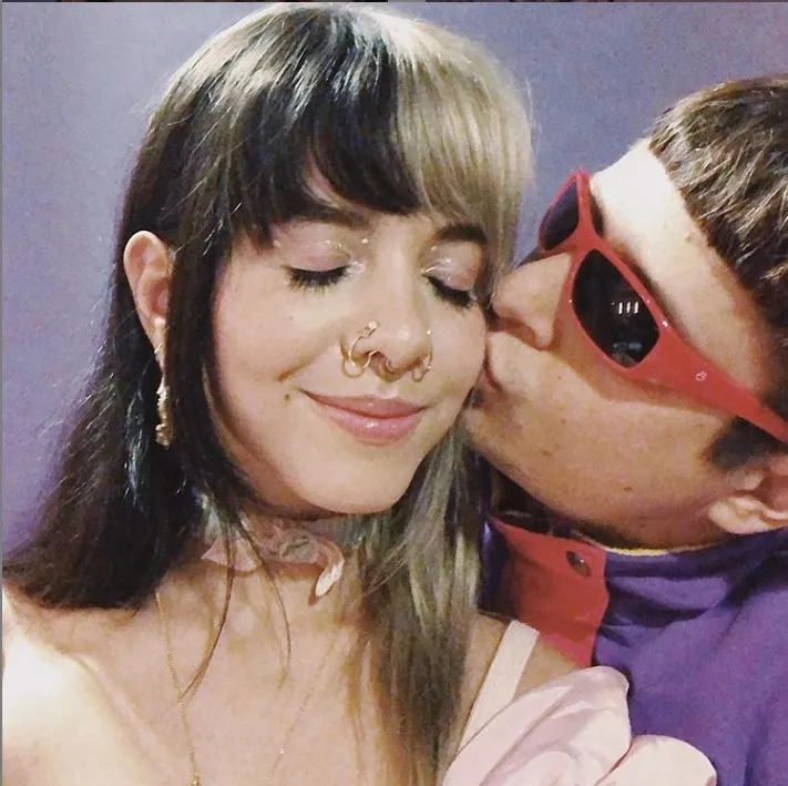 Melanie Martinez being kissed on the cheek by Oliver Tree.