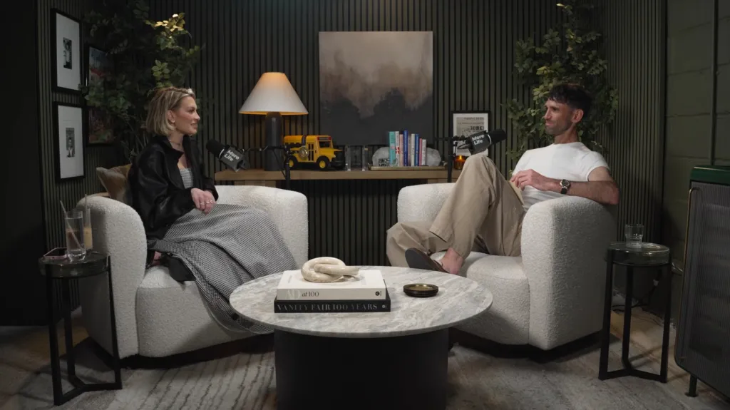 Two people sitting in armchairs talking on a podcast called 