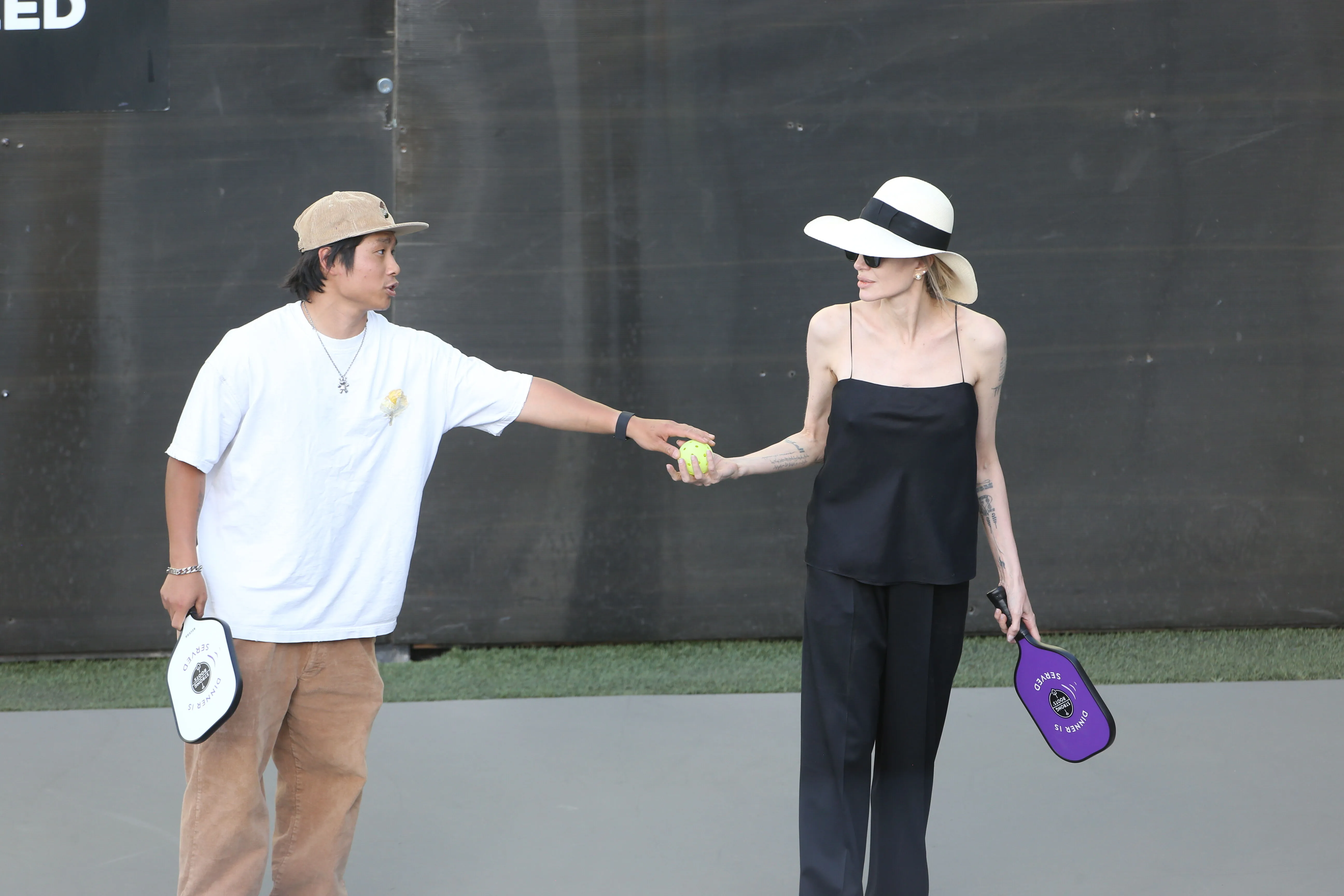 Angelina Jolie and another person playing pickleball.