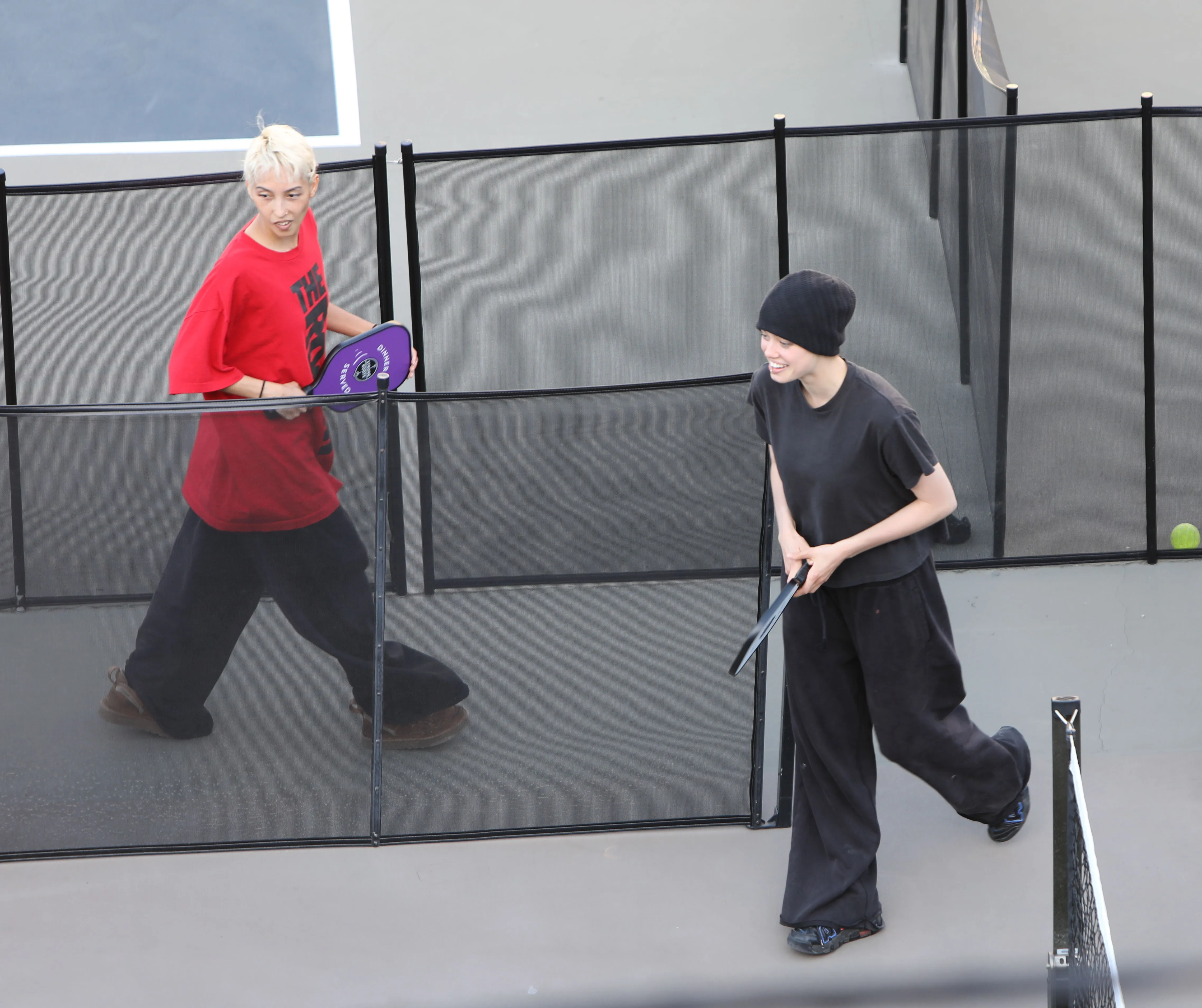 Shiloh Jolie-Pitt and Keoni Rose playing pickleball on a court.