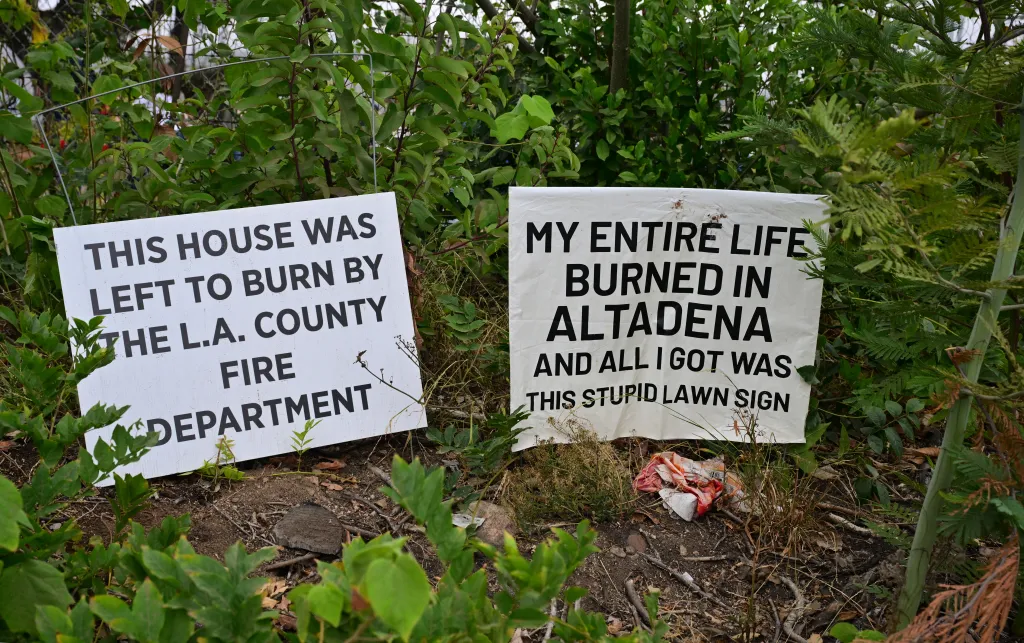 Two protest signs about a fire. The left sign reads
