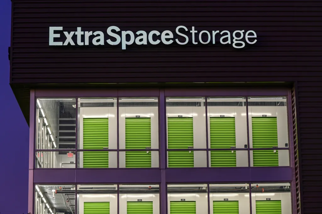 Exterior view of an Extra Space Storage self-storage facility with illuminated signage and visible storage units.