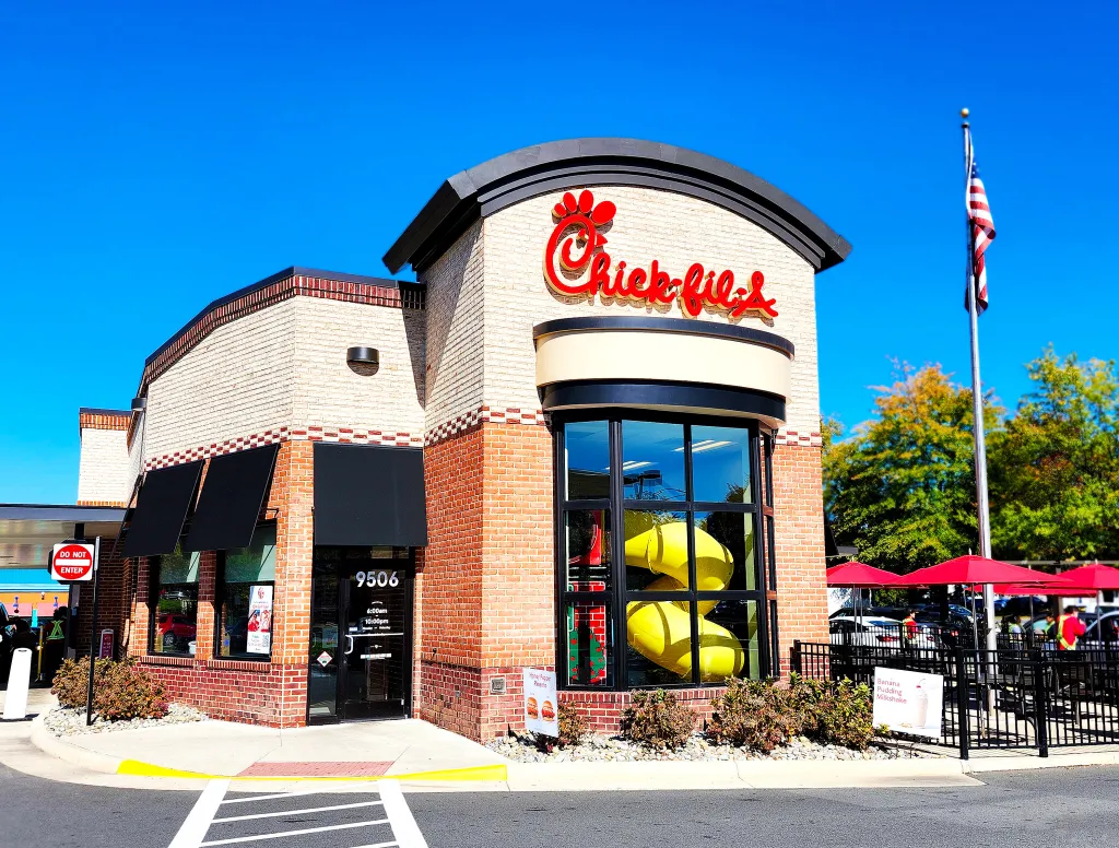 Chick-fil-A restaurant exterior in Manassas, Virginia, featuring the logo, drive-thru, and an American flag.