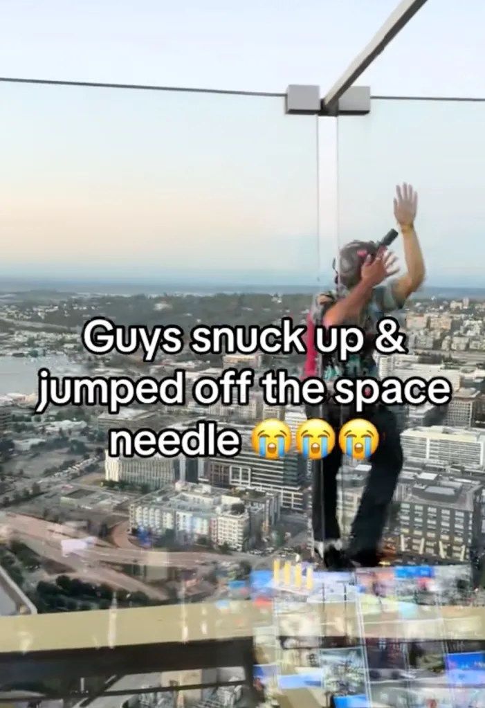 A man with headphones and a microphone appears to be standing on the edge of a tall building, above a city skyline.