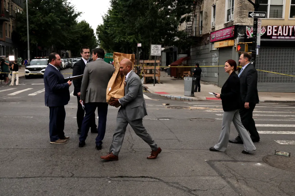 NYPD Crime Scene Unit detectives investigate the scene where an officer was shot in Crown Heights, Brooklyn.