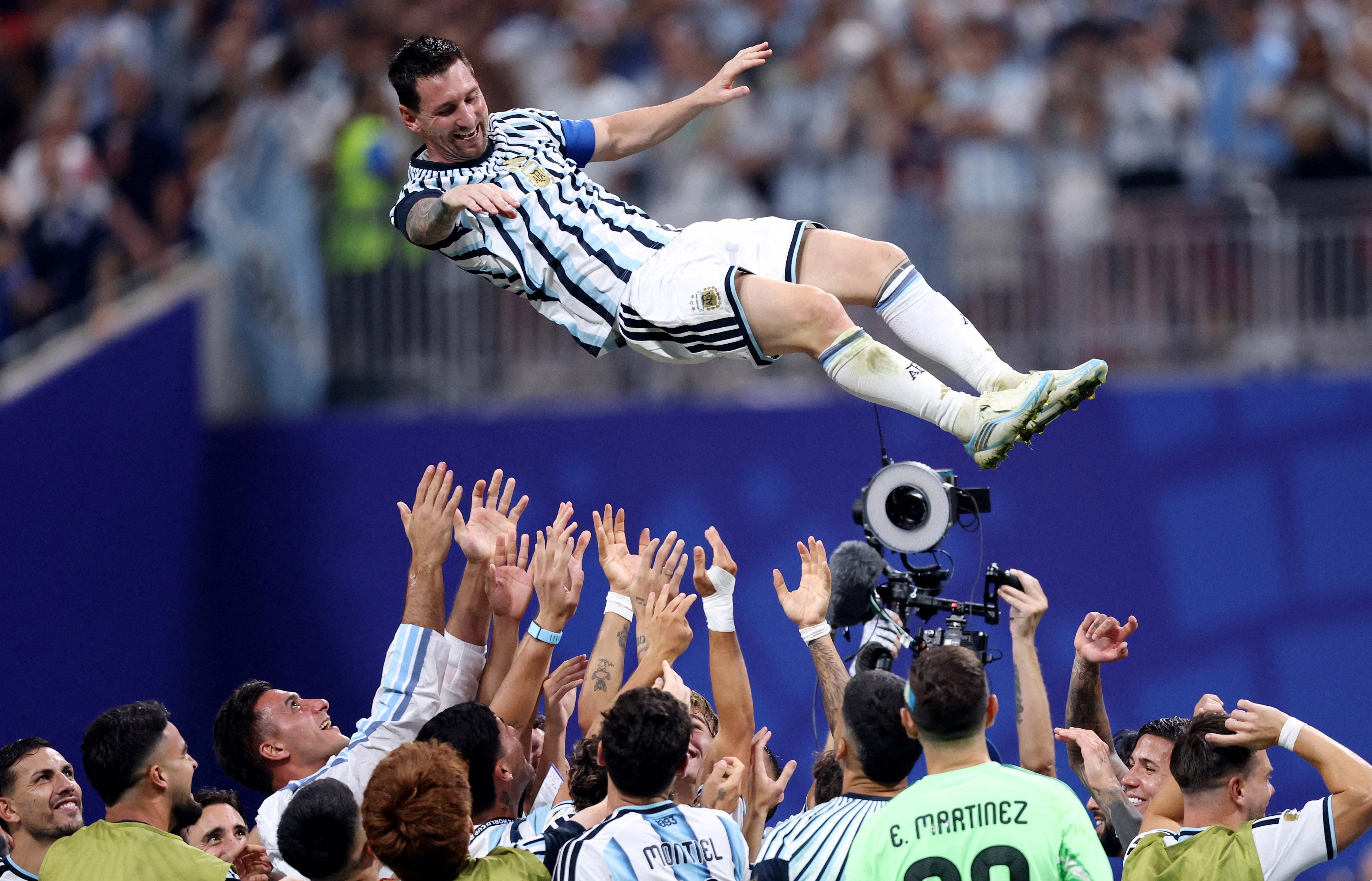 Argentina’s Lionel Messi is thrown in the air in celebration by teammates.